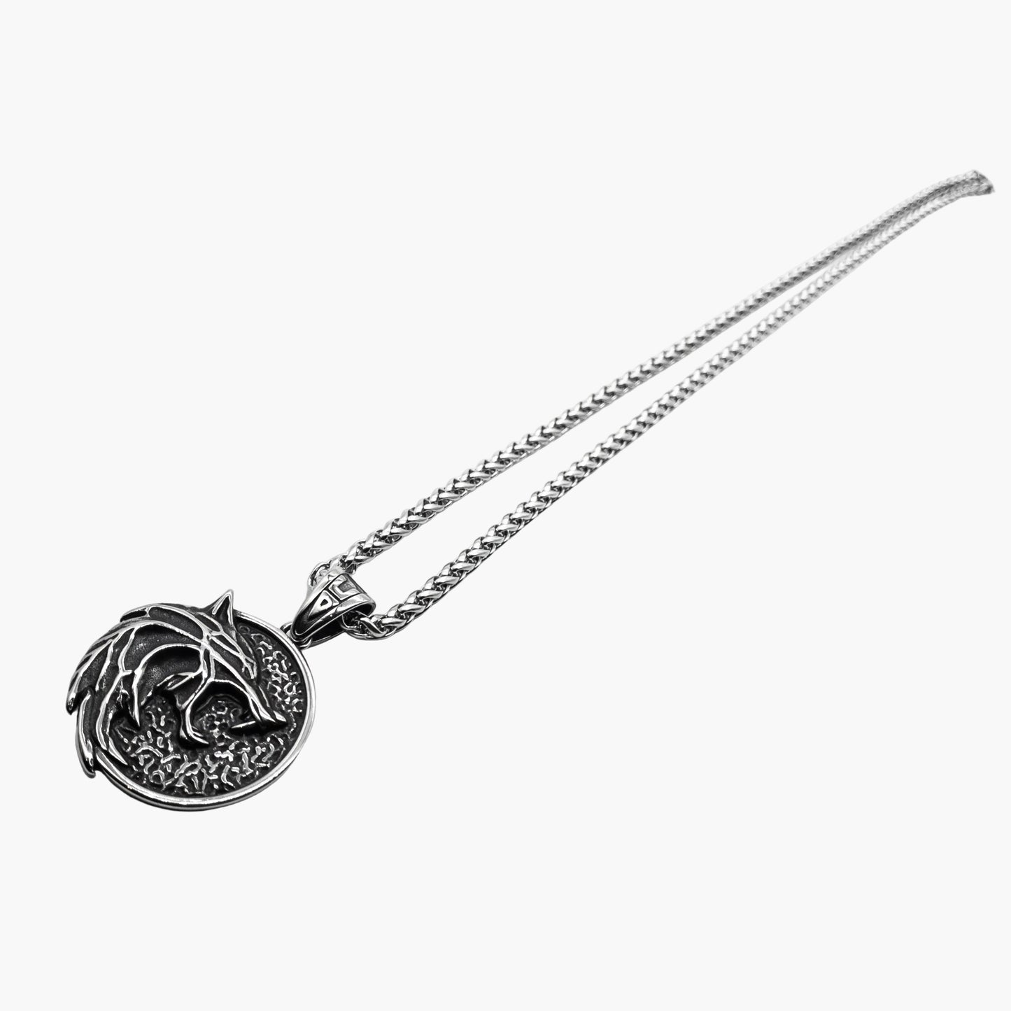 left angle view of Skoll Chain wolf pendant showing engraving depth