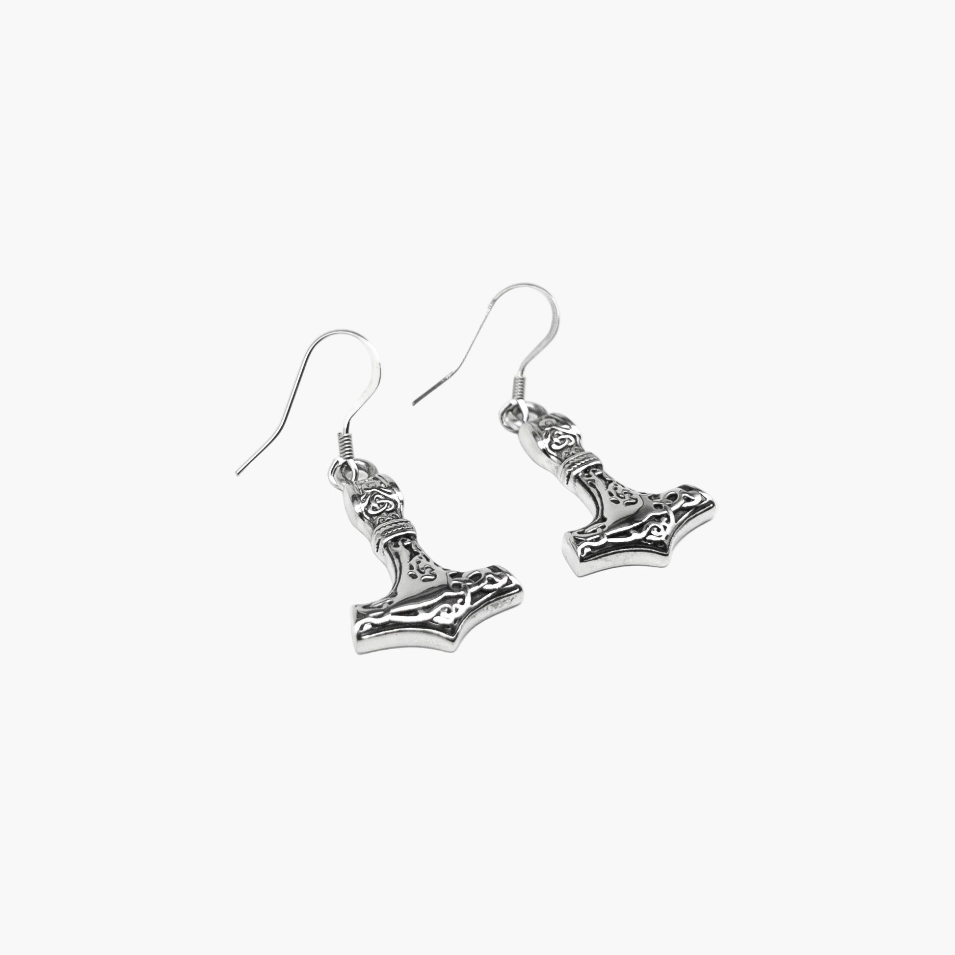 Close-up of Valkyrie Hammer earrings highlighting precise engraving and minimalist silver finish.